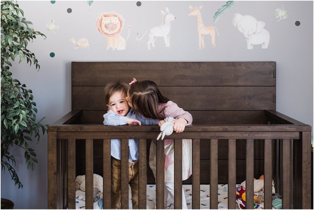 One year old boy and his big sister in his crib during boy's first birthday photo session at home in New Jersey with a family of four in the nursery | 
NJ Family Photographers Renee Ash Photography 