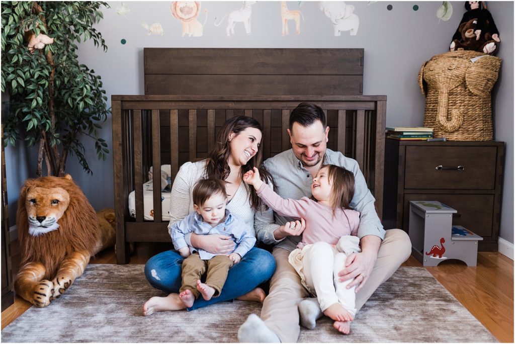 Family of four sitting next to the crib during boy's first birthday photo session at home in New Jersey with a family of four in the nursery | 
NJ Family Photographers Renee Ash Photography 