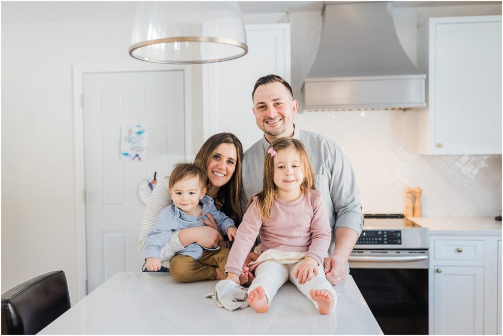 One year old boy first birthday photo session at home in New Jersey with a family of four in their beautiful white and grey kitchen | 
NJ Family Photographers Renee Ash Photography 