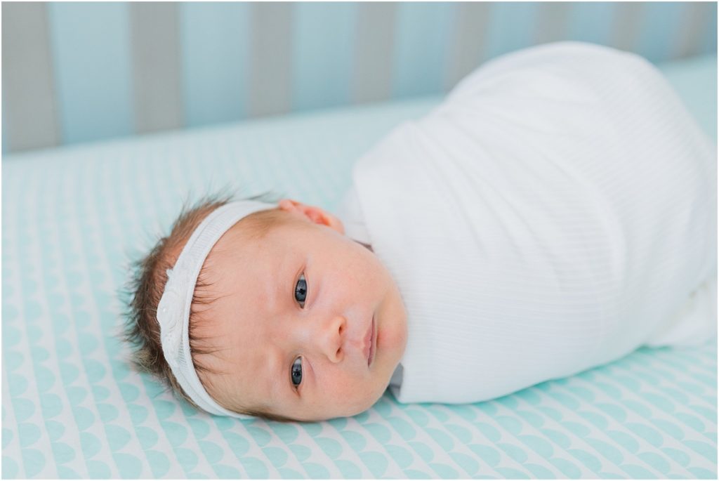 Newborn pictures at home baby in her crib teal and white 