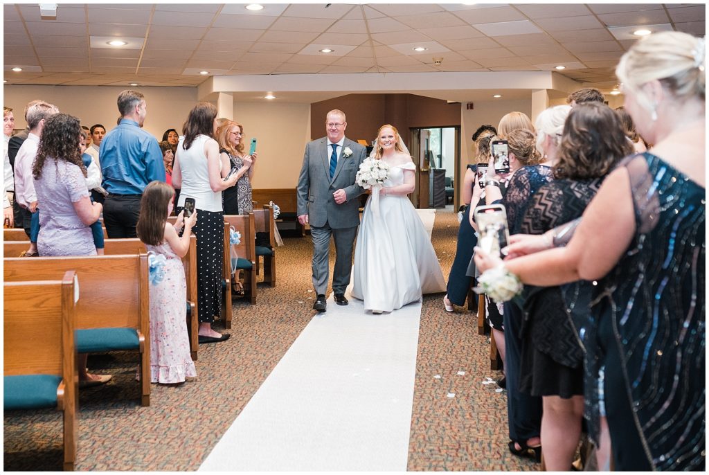 Bride and dad  walk down the aisle on her wedding day at Grace Church Randolph NJ. Photo by Renee Ash Photography