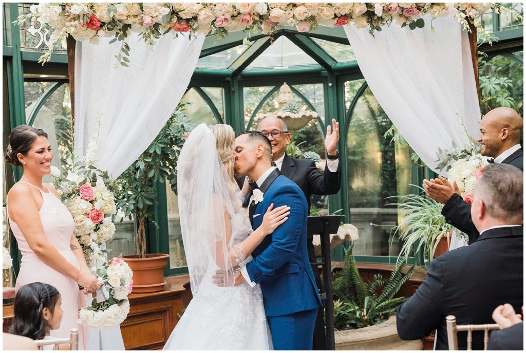 Bride and Groom first kiss during their ceremony at the Grand Conservatory at the Brownstone.  Renee Ash Photography
