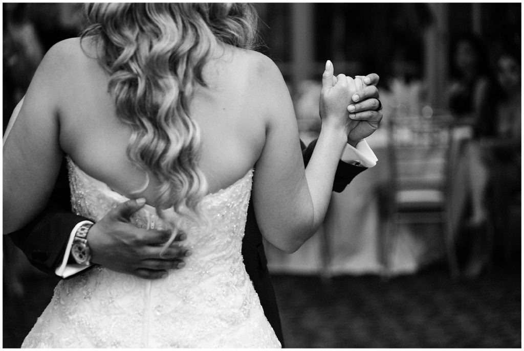 Black and white photo of the bride and groom holding hands during their first dance  at the brownstone.  Renee Ash Photography