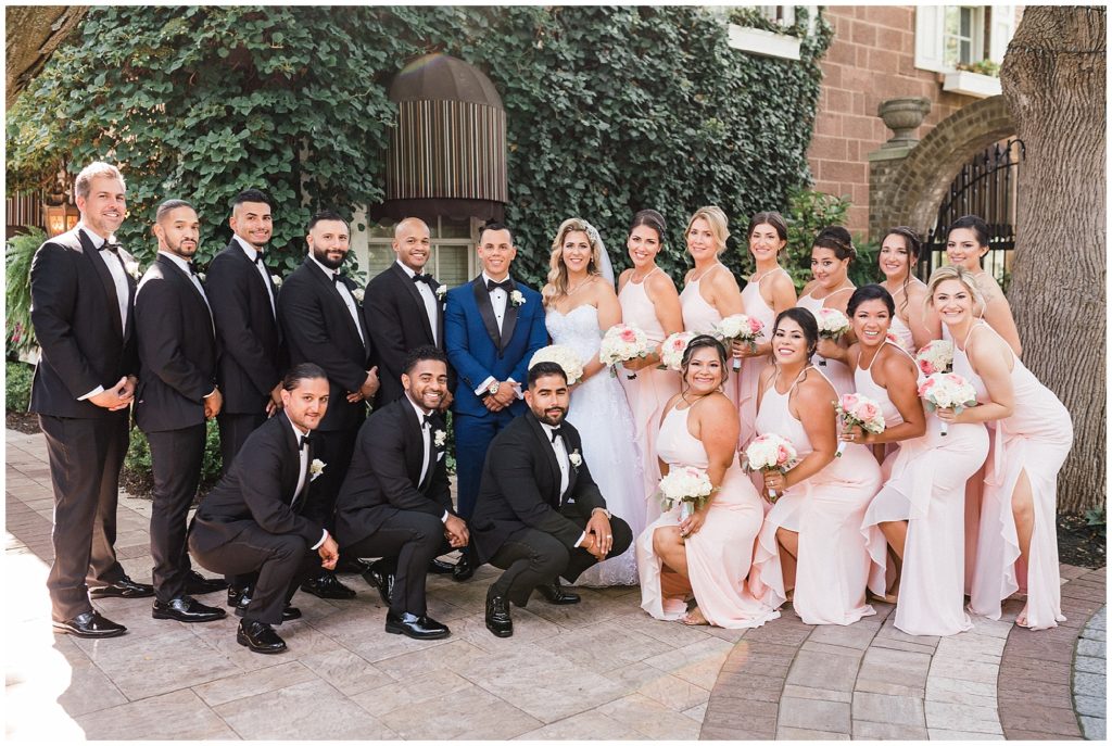 Large bridal party at the Brownstone. Pink bridesmaid dresses with white and pink bouquets. Men in Mens Wearhouse black and white tuxes.   Renee Ash Photography