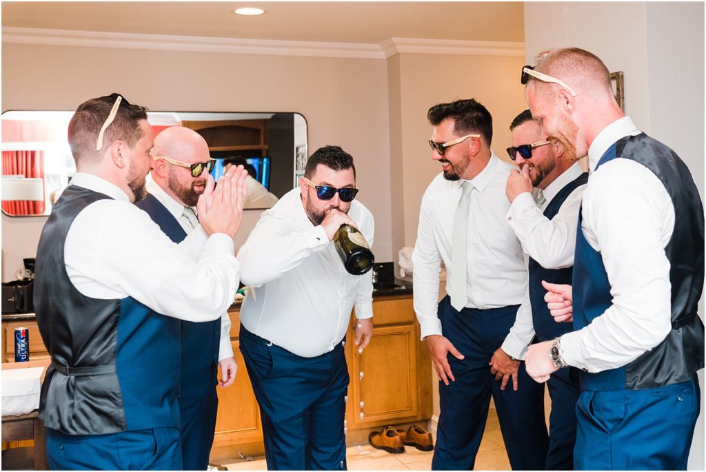 Groom getting ready the morning of his wedding. Popping champagne with the groomsmen. Ballyowen at Crystal Springs summer wedding. Renee Ash Photography