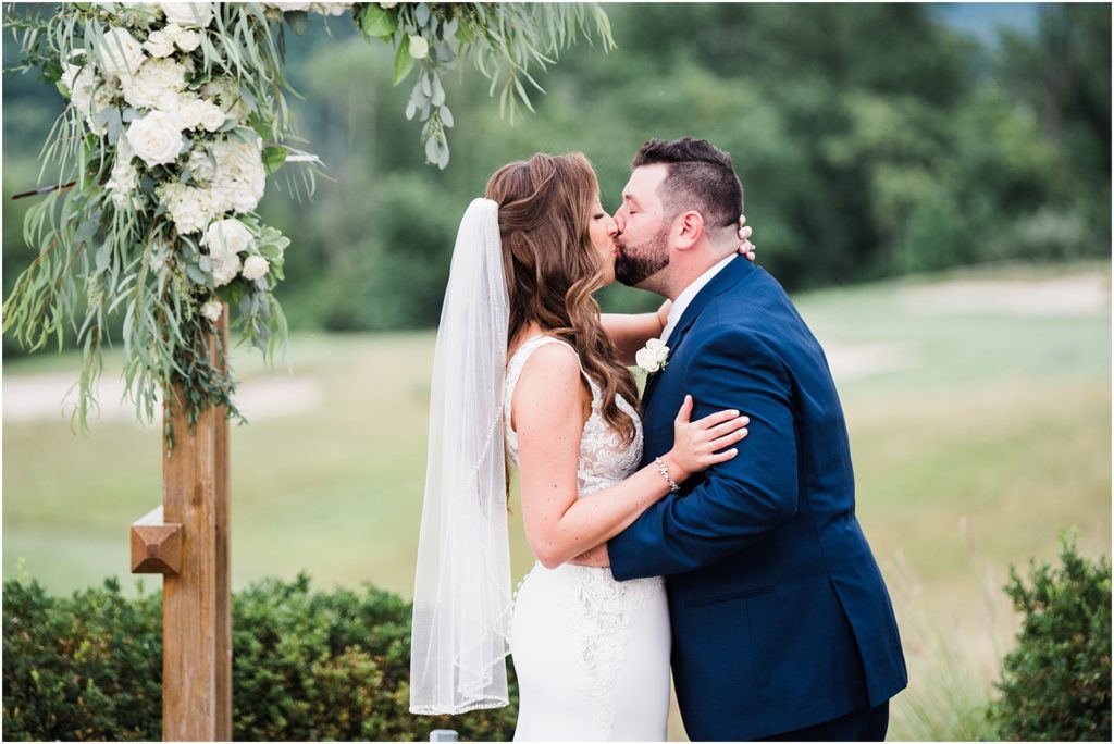 Bride and groom share their first kiss during their wedding ceremony. Ballyowen at Crystal Springs summer wedding. Renee Ash Photography, Hardyston NJ 