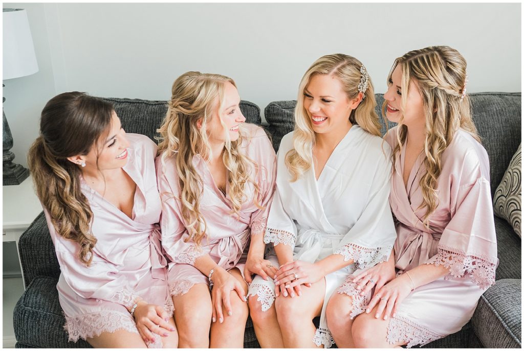 Bride and her bridesmaids in pink and white robes while getting ready at The Club at Picatinny.  New Jersey wedding venue. Renee Ash Photography