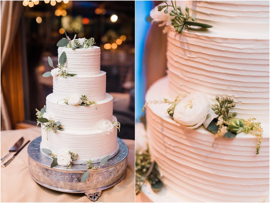 White wedding cake with white ranuculus and greenery. 
