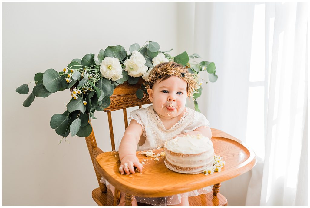 vintage high chair with florals. simple boho first birthday girl pictures with sister in a photo studio in vernon new jersey 