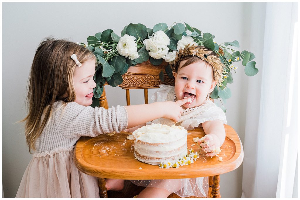 boho first birthday cake smash with sibling in a photo studio in sussex county new jersey 