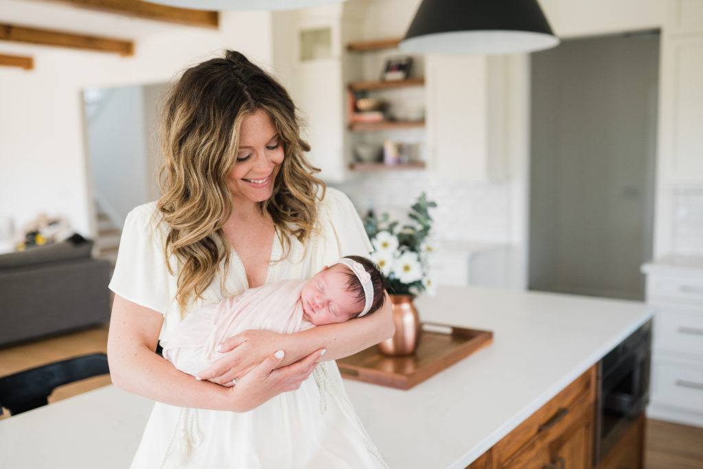 The why behind the photographs. Mom holding her newborn baby in their home. Farmhouse kitchen family photos. The why behind the photographs. Family in home lifestyle photography in Warwick New York by Renee Ash. 