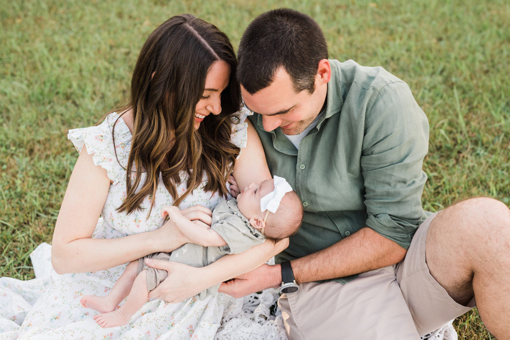 Spring family of three holding newborn baby outside newborn photography Vernon New Jersey by Renee ash photography