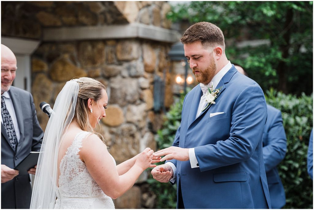  Exchanging of the rings in the courtyard ceremony space of The Olde Mill Inn Wedding Venue in Northern NJ. by Renee Ash Photography 