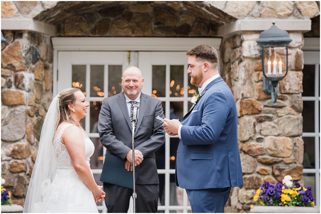 Bride and Groom saying their vows to one another in the courtyard ceremony space of The Olde Mill Inn Wedding Venue in Northern NJ. by Renee Ash Photography 