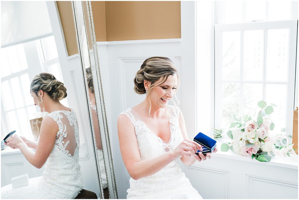 Bride opening A gift from the groom on their wedding day at the Coach house at the Ryland Inn. New Jersey Wedding photographer