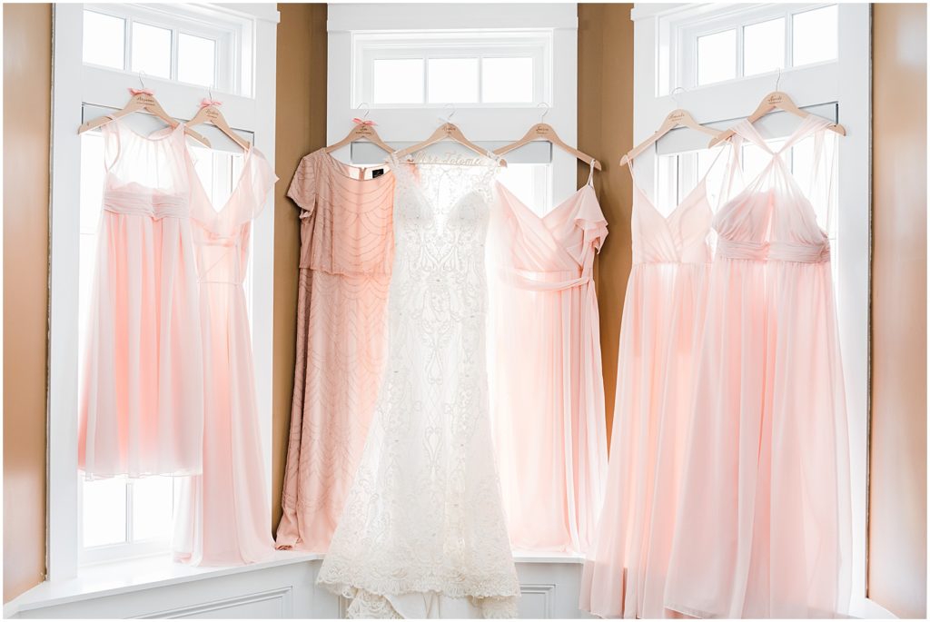 Pink bridesmaids gowns hung in a window at the Ryland Inn Bridal cottage.