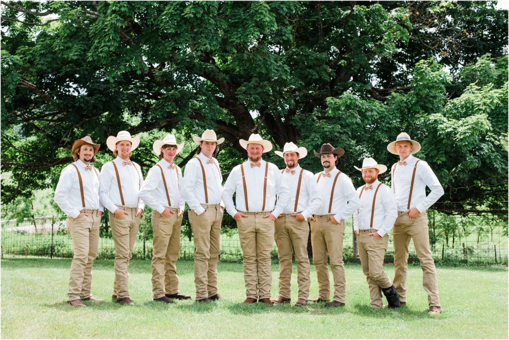 grooms party photo, guys with cowboy hats, suspenders, bowties in rust and khaki jeans