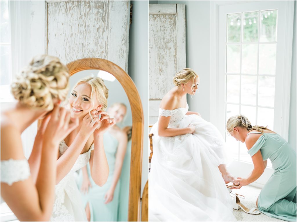 bride getting ready. putting in her earrrings in the mirror and her bridesmaid helping to put on her shoes like cinderella. 