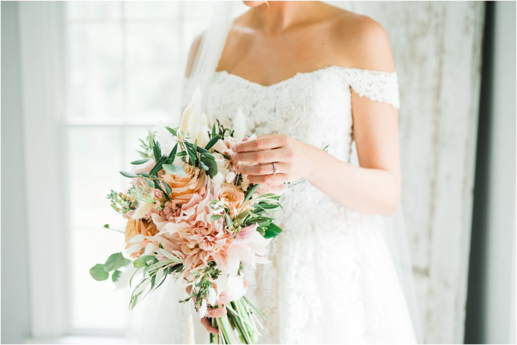 Bride holding her peach and pink bridal bouquet by farmside gardens florist in sussex NJ. 