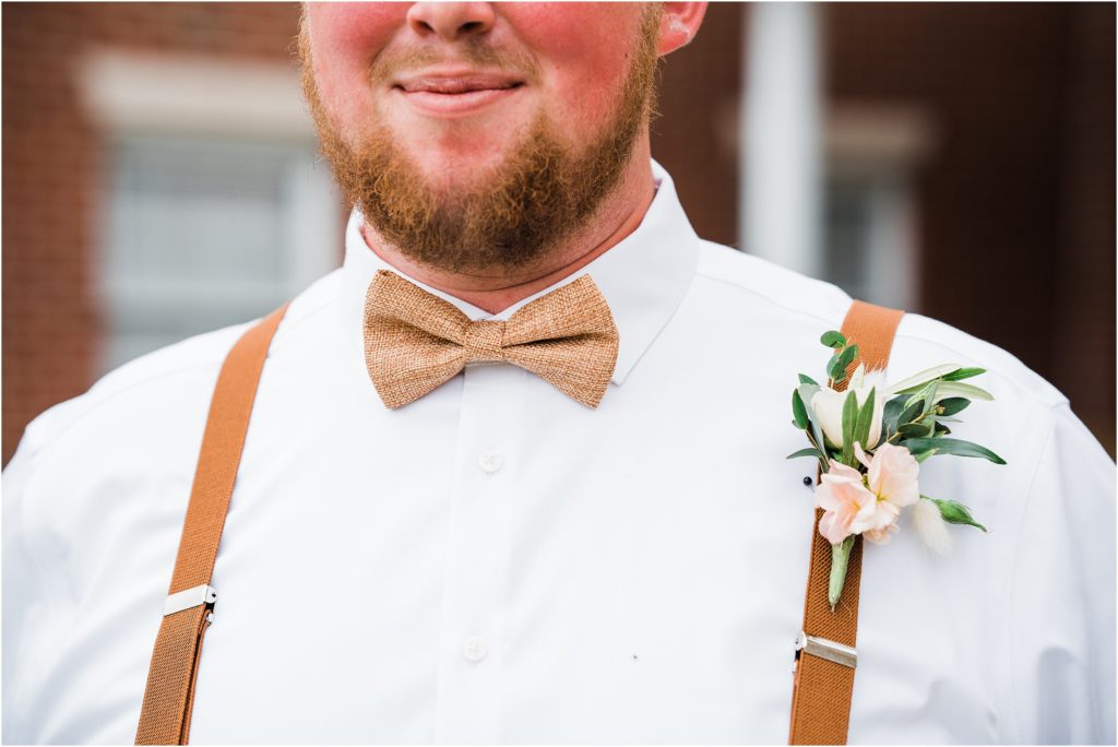 groom's peach rust and pink. boutonnierre by farmside gardens florist in sussex. rust colored suspenders and bowtie