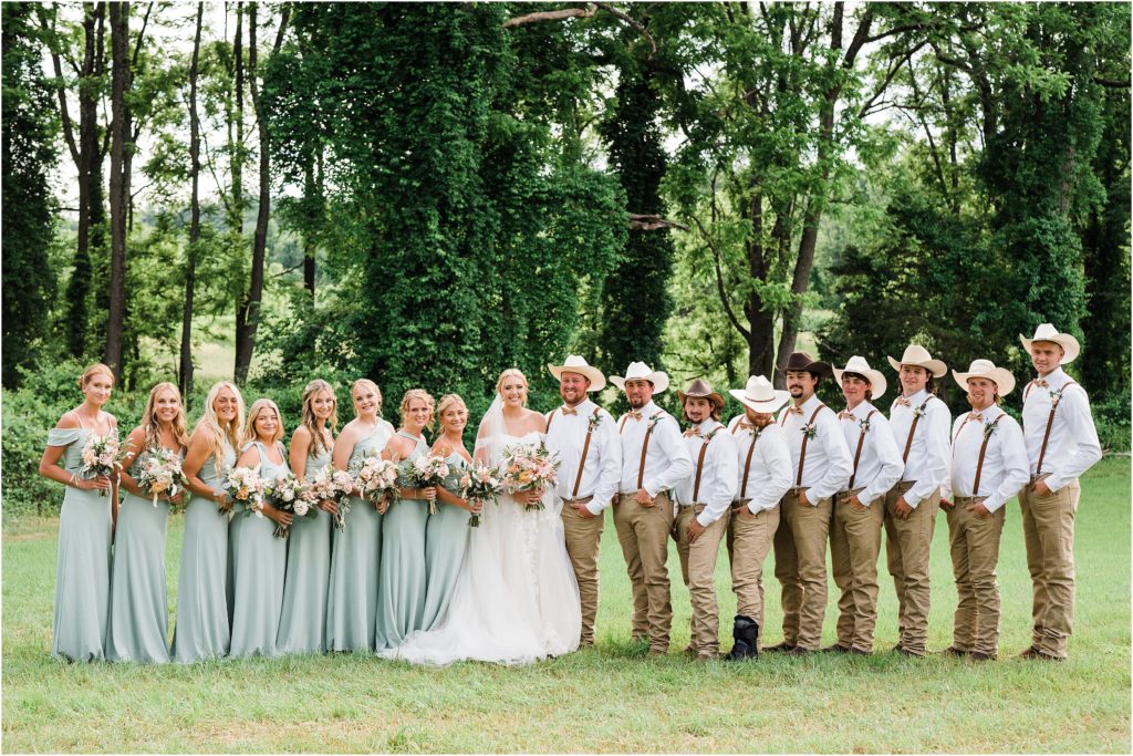 Wedding party photo, guys with cowboy hats, suspenders and khaki jeans, girls wearing birdy grey gowns in sage.