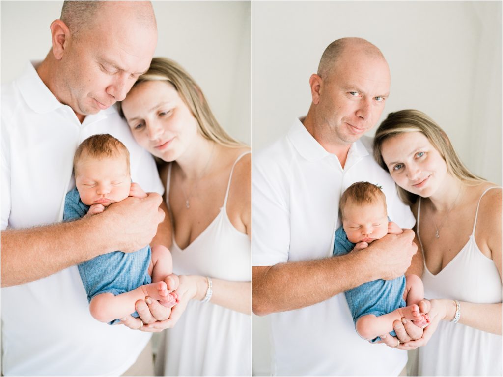 Planning a newborn session in studio with mom and dad and a baby boy in a blue onesie. All white background and natural lighting. Renee Ash Photography, SUssex County NJ photo studio