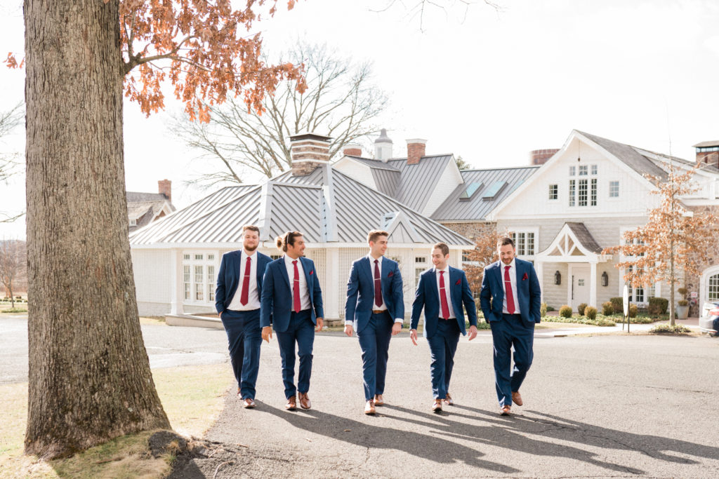 Groomsmen photo walking at the Ryland Inn Coach house. Wedding trend for 2023 No boutonniers 