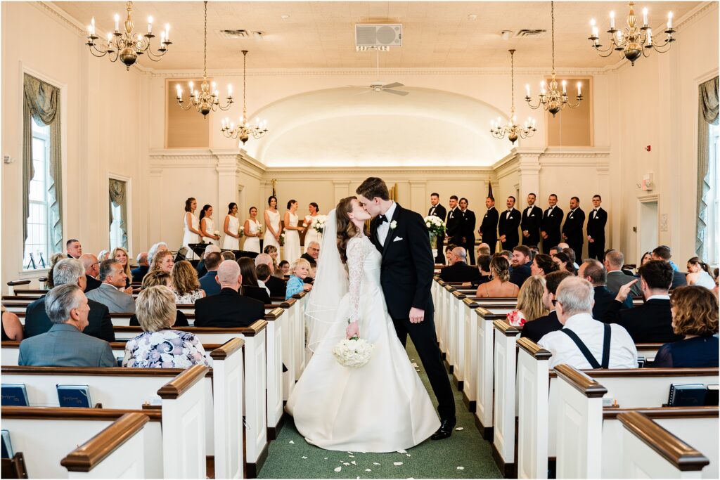 The kiss, halfway down the aisle. Reformed baptist church of Lafayette wedding. Traditional black and white wedding by Renee ash photography
