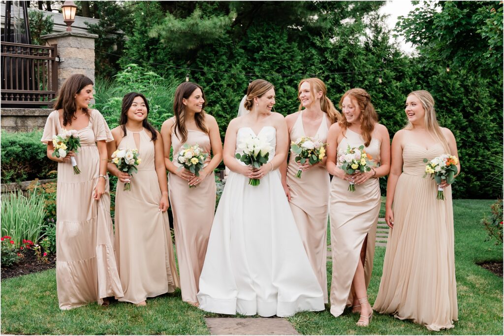Wedding party portraits at the Sherwood chalet at Forest Lodge wedding venue. Champagne bridesmaids dresses, navy groomsmen suits with champagne ties.  white yellow and pink Bouquets by The Botanical Box. Renee Ash Photography, NJ wedding 