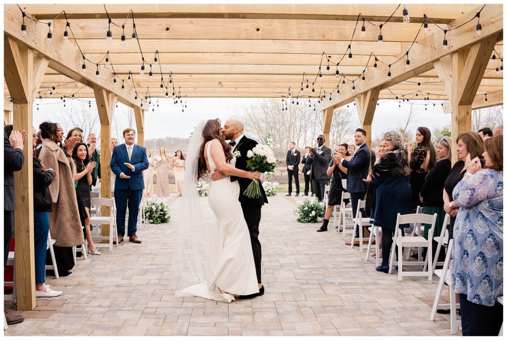 bride and groom kissing in the aisle at The Barn at Villa Venezia Goshen NY wedding photographer