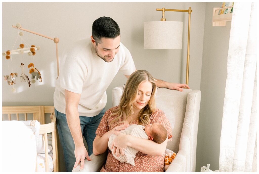 In home newborn photography session in Morris County New Jersey with parents holding their baby in soft natural light