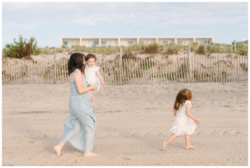 Mom and her children running along the New Jersey Shore on Long Beach Island at sunrise on the beach. NJ Shore family beach vacation photographer Renee Ash Photography