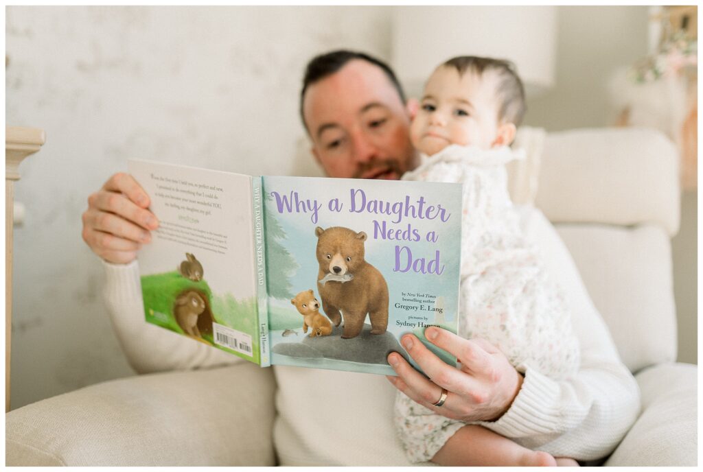 Lifestyle photo of father reading to toddler in Madison NJ family home. " Why a daughter needs a dad" baby storybook for baby shower gift.