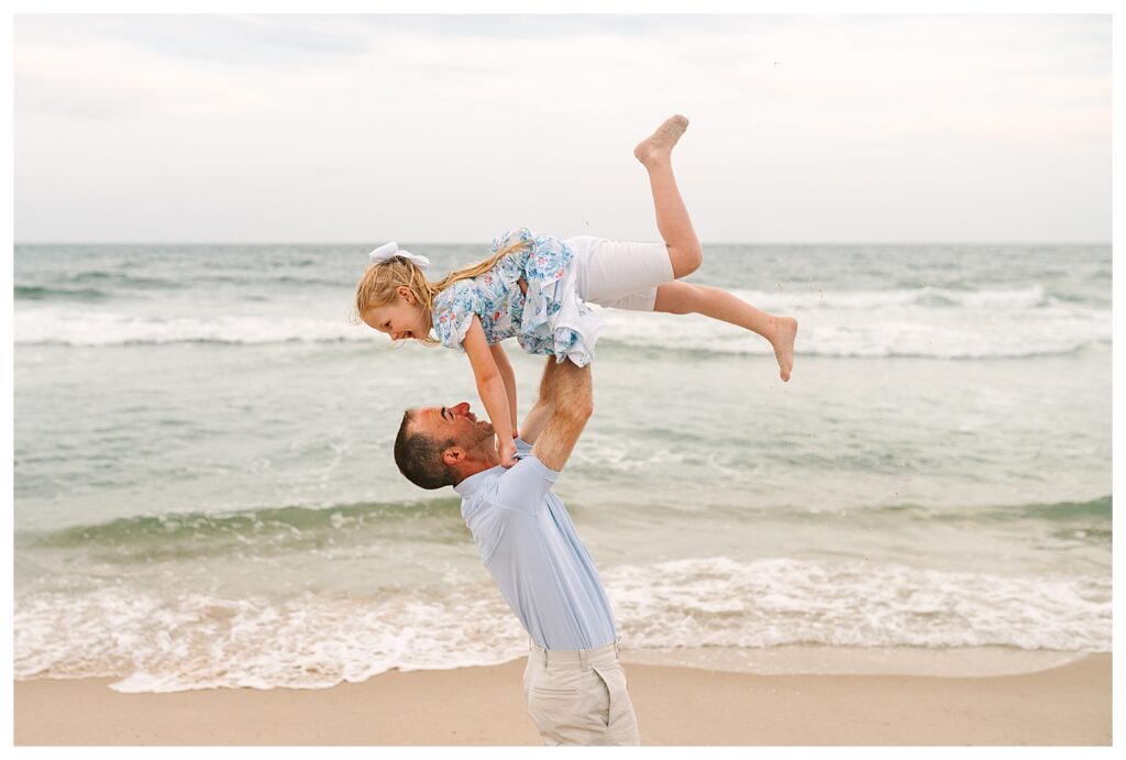 Family laughing together on the sand, capturing candid joy during a Long Beach Island beach photo session