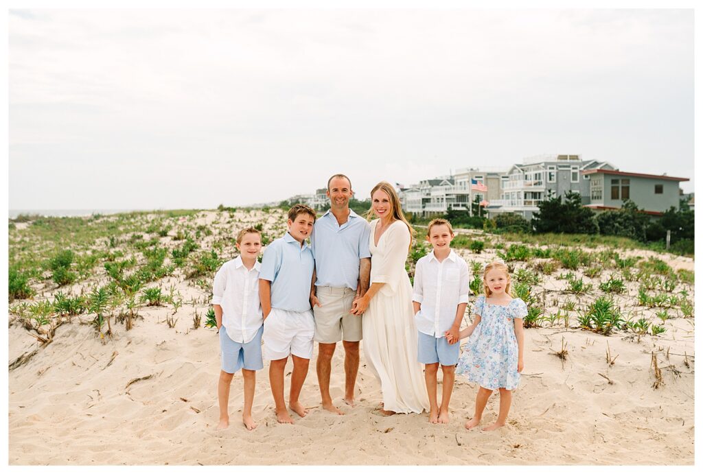Extended family group portrait standing together on the beach with soft sunset light in New Jersey